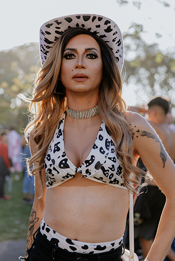 Drag Queen posando para a foto em close. Ela veste um maiô de onça e um chapéu também com a mesma estampa. É branca tem cabelo loiro e tem uma corrente no pescoço. Drag Queen na 7ª Marcha pela Diversidade de Curitiba, em 2024